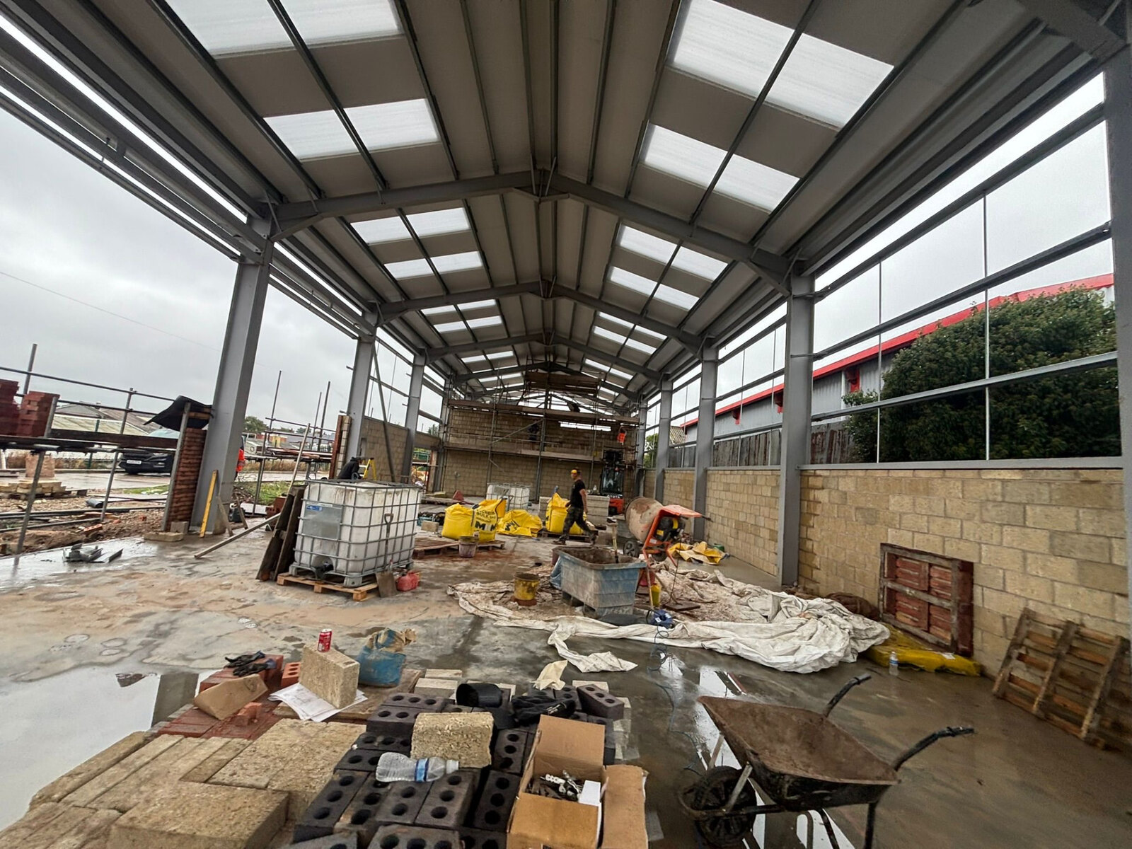 Interior of a commercial steel framed unit with blockwork walls being built by bricklayers