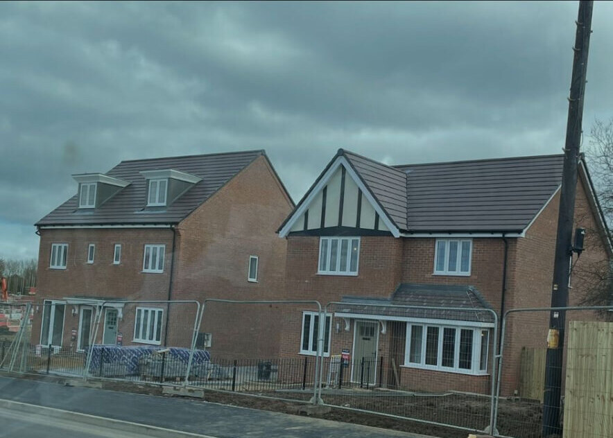 Completed new build homes with red brick elevations and Tudor style gable detailing