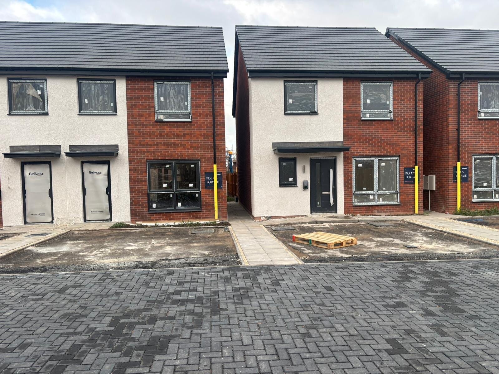 Completed new build houses in red facing brick and render on a Bellway development