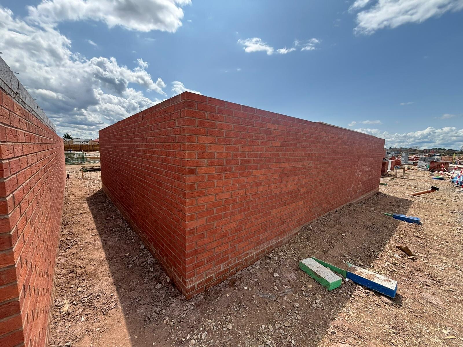 Newly built red brick garage walls on a housing development plot