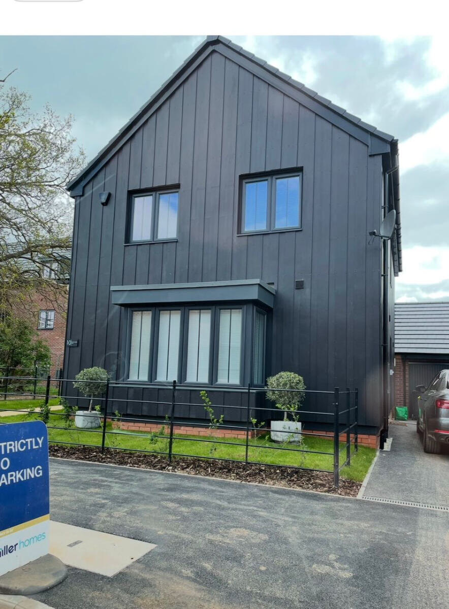 Completed new build home with dark cladding and brickwork on a Derby development