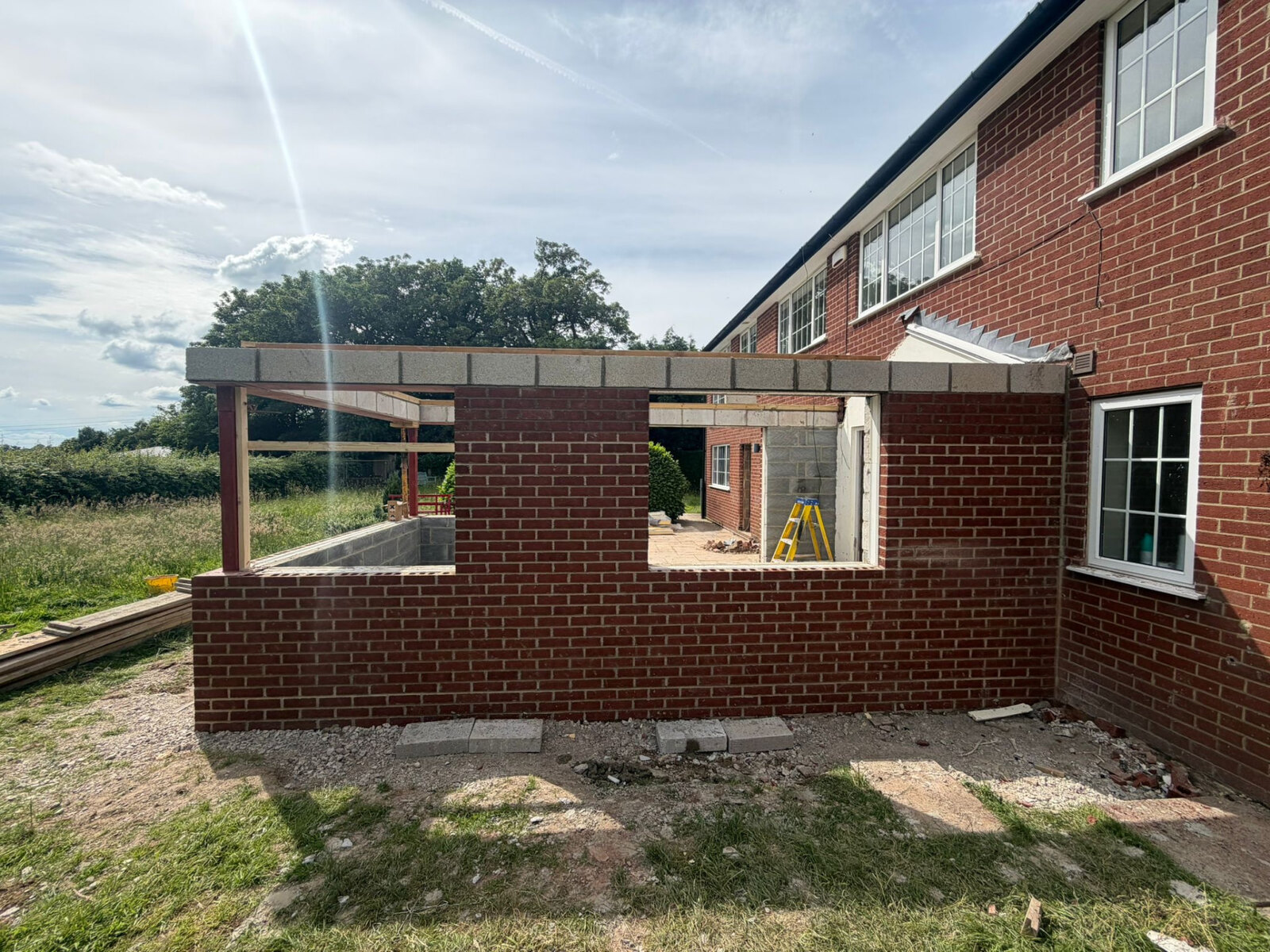 Single storey extension shell in red brickwork with large openings and blockwork inner leaf