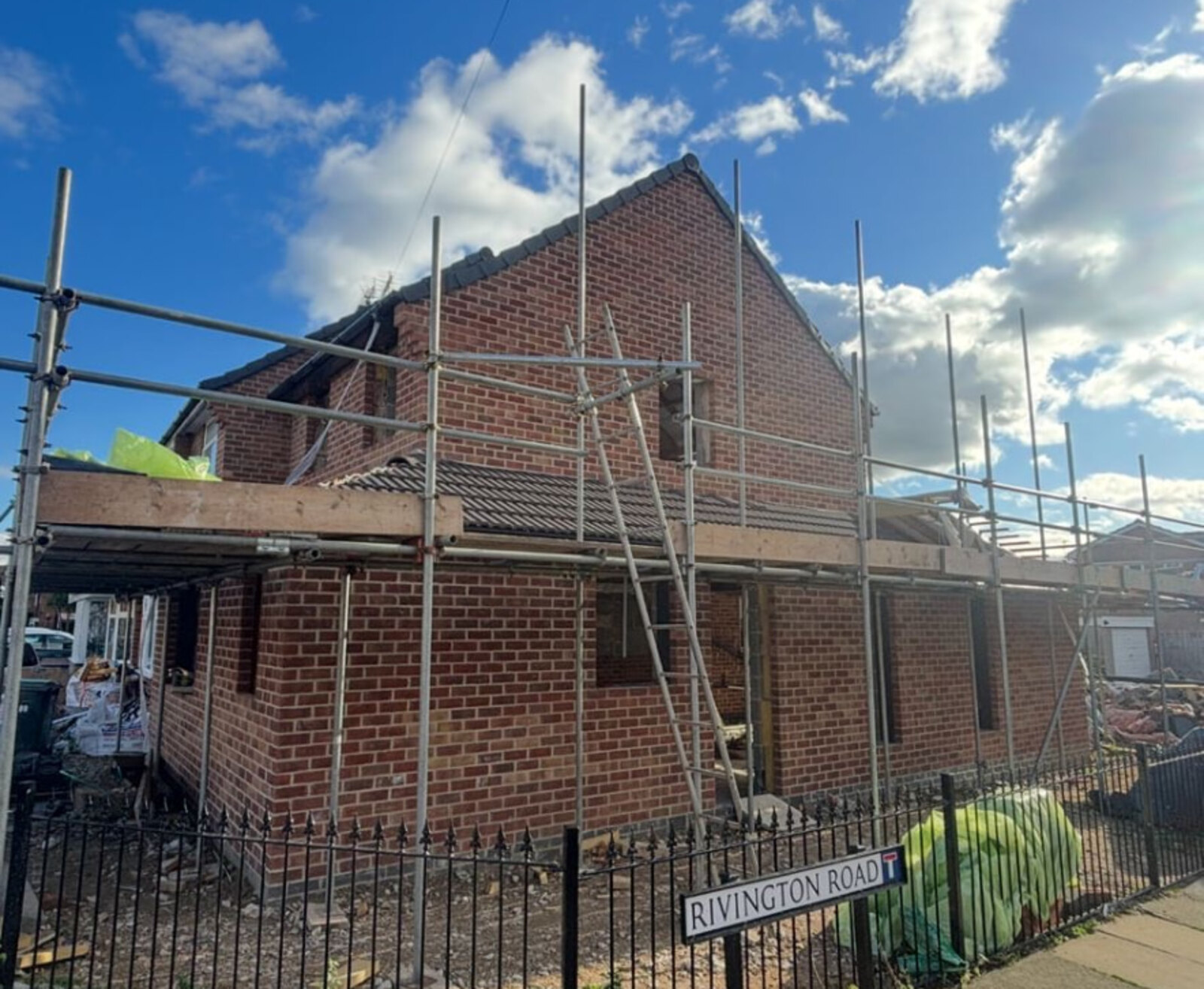 Two storey side and rear extension in red brickwork under scaffold on a Derby home
