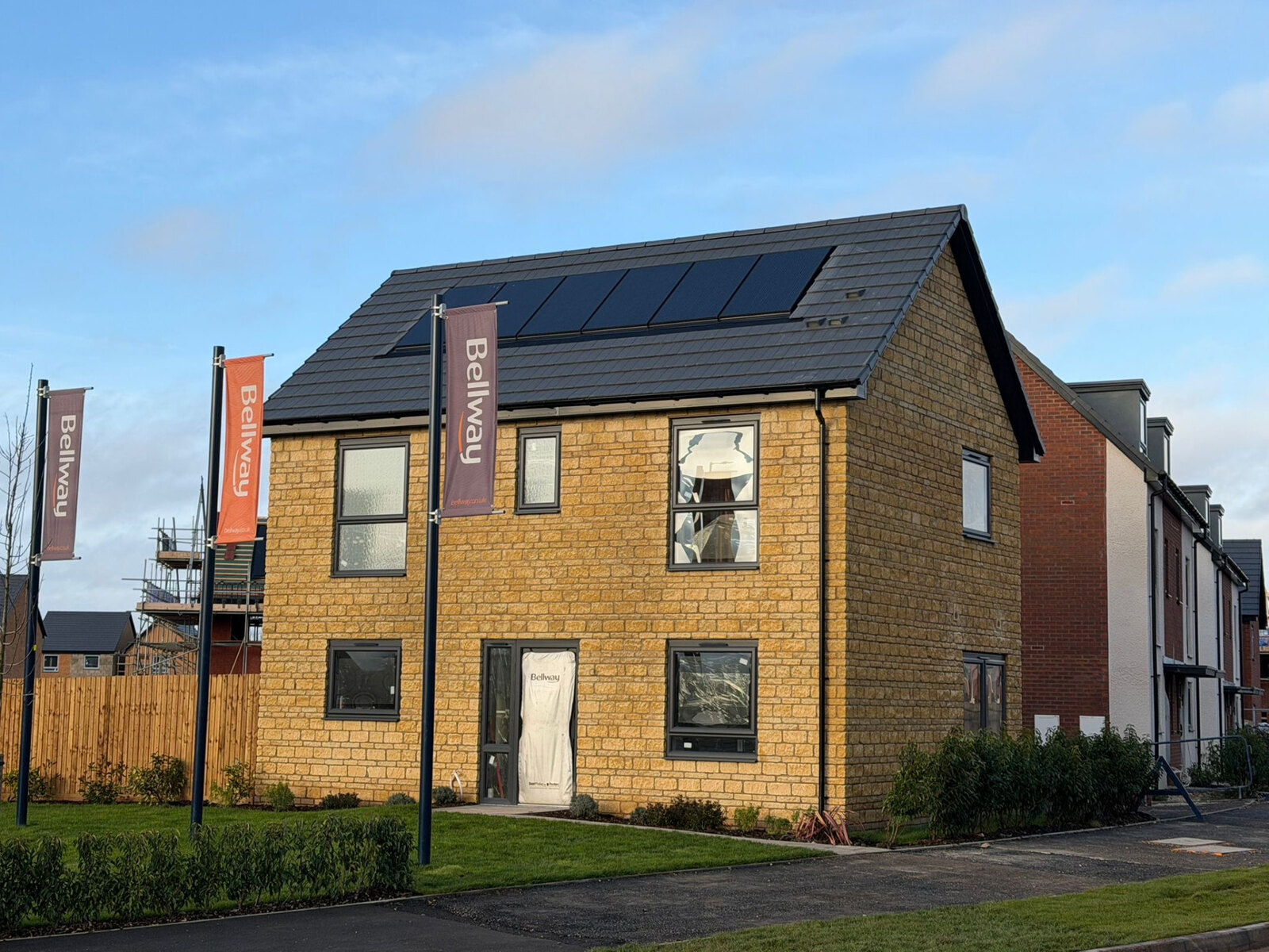 Reconstituted stone show home with feature brick gable on a Bellway development