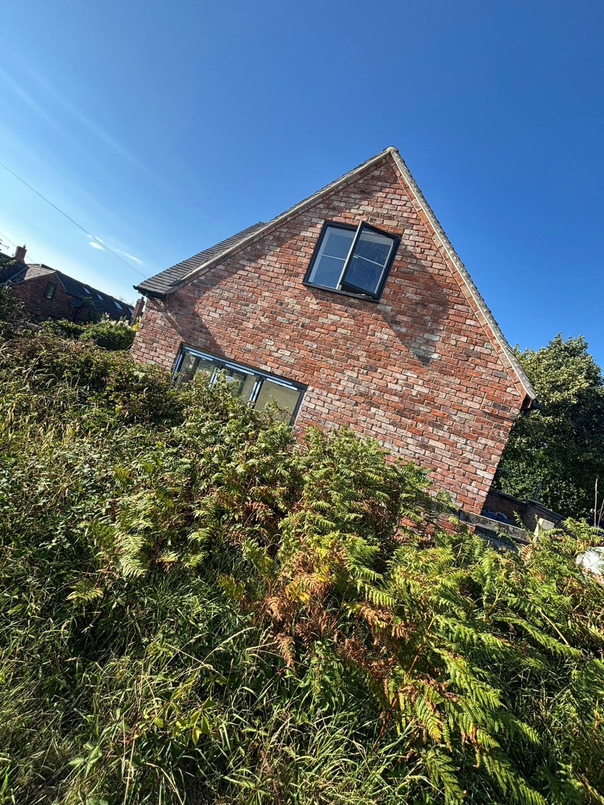 Restored reclaimed brick gable end with new window openings and bifold doors