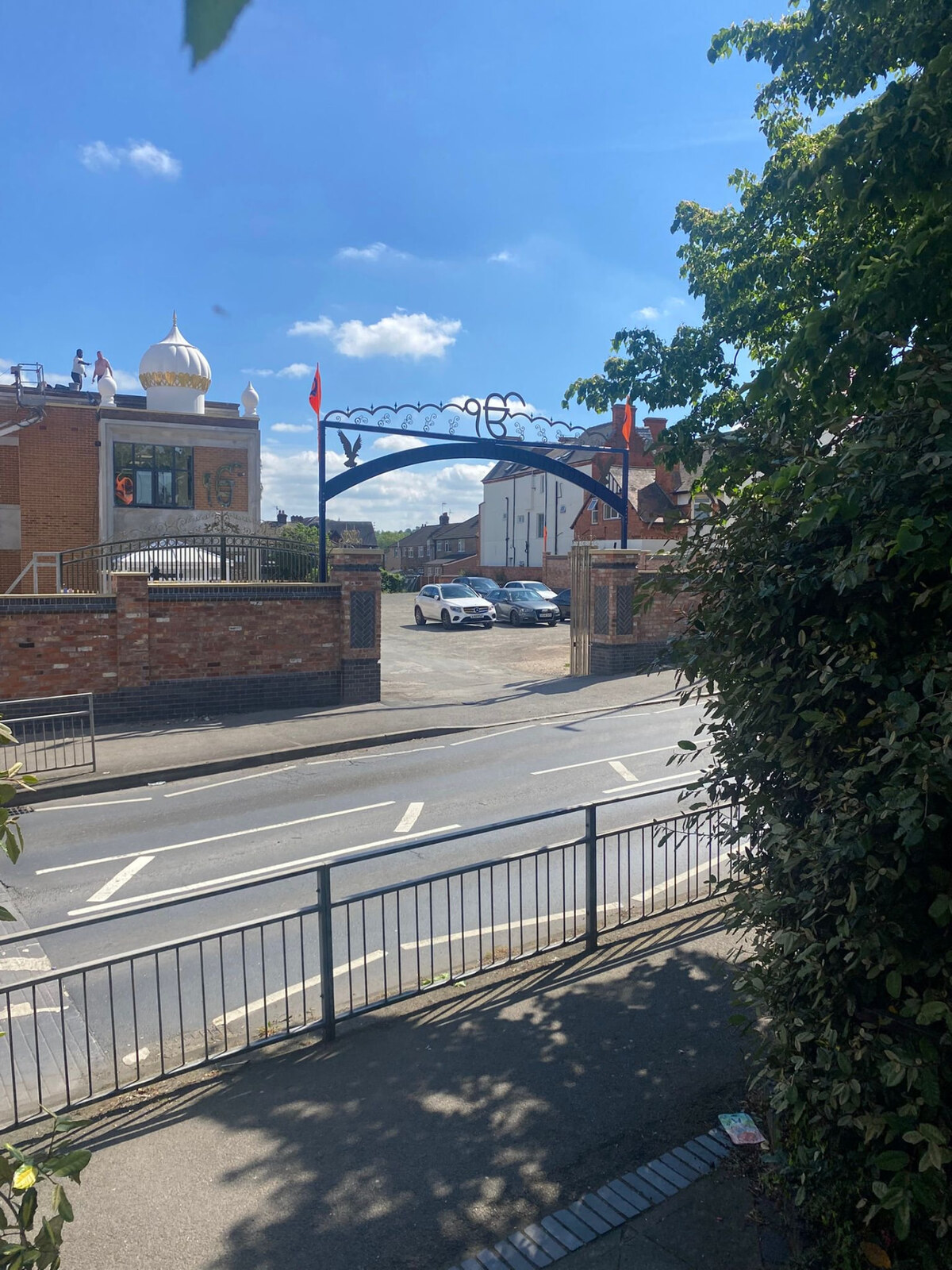 Brick boundary wall with blue brick detailing and entrance piers to a community building