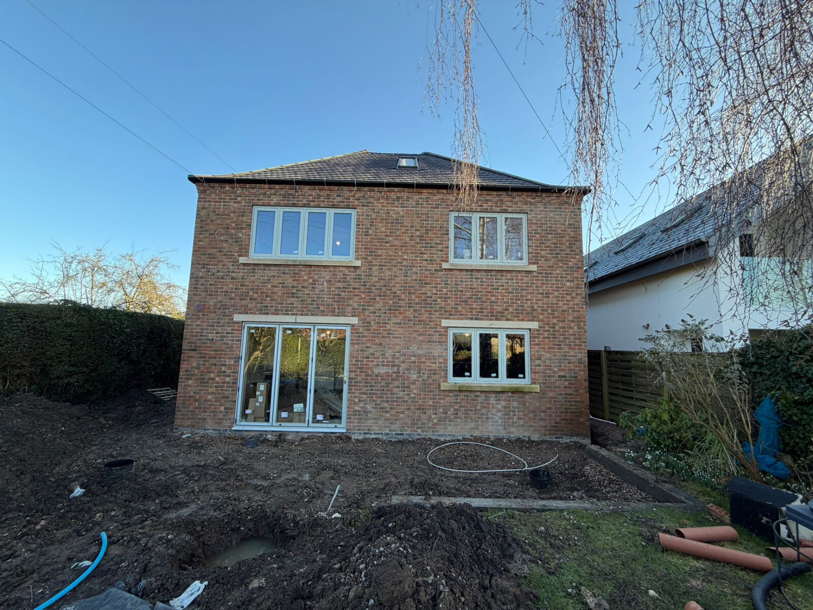 Completed two storey rear extension in red brickwork with stone cills and bifold opening