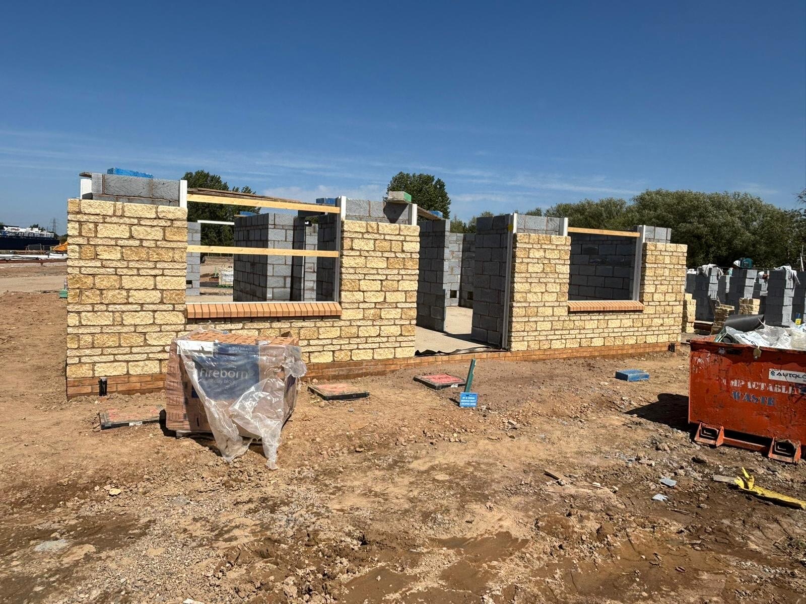 New build plot at first lift with stone outer leaf, blockwork inner leaf and brick cill course