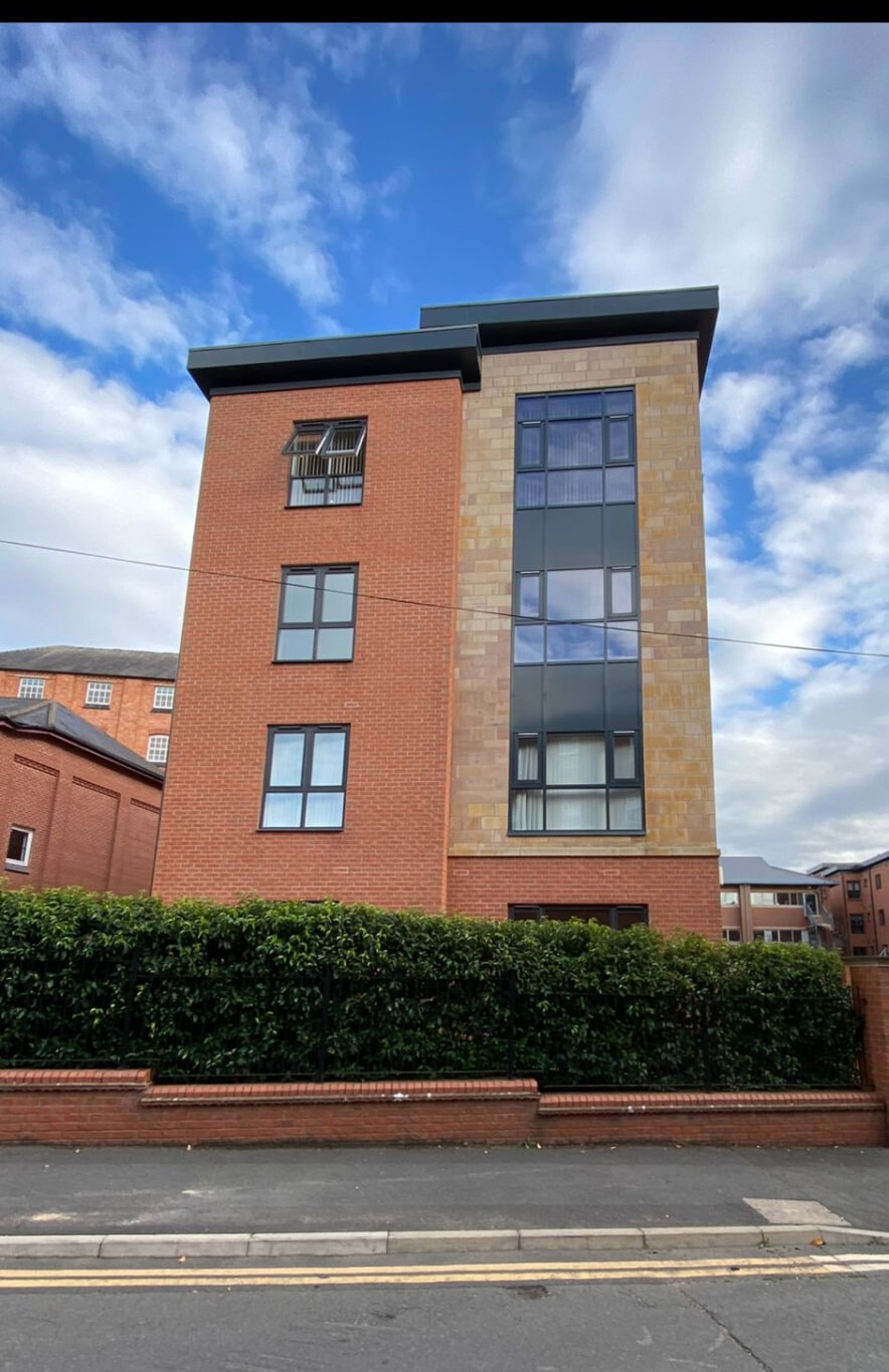 Completed apartment elevation combining red facing brickwork and reconstituted stone