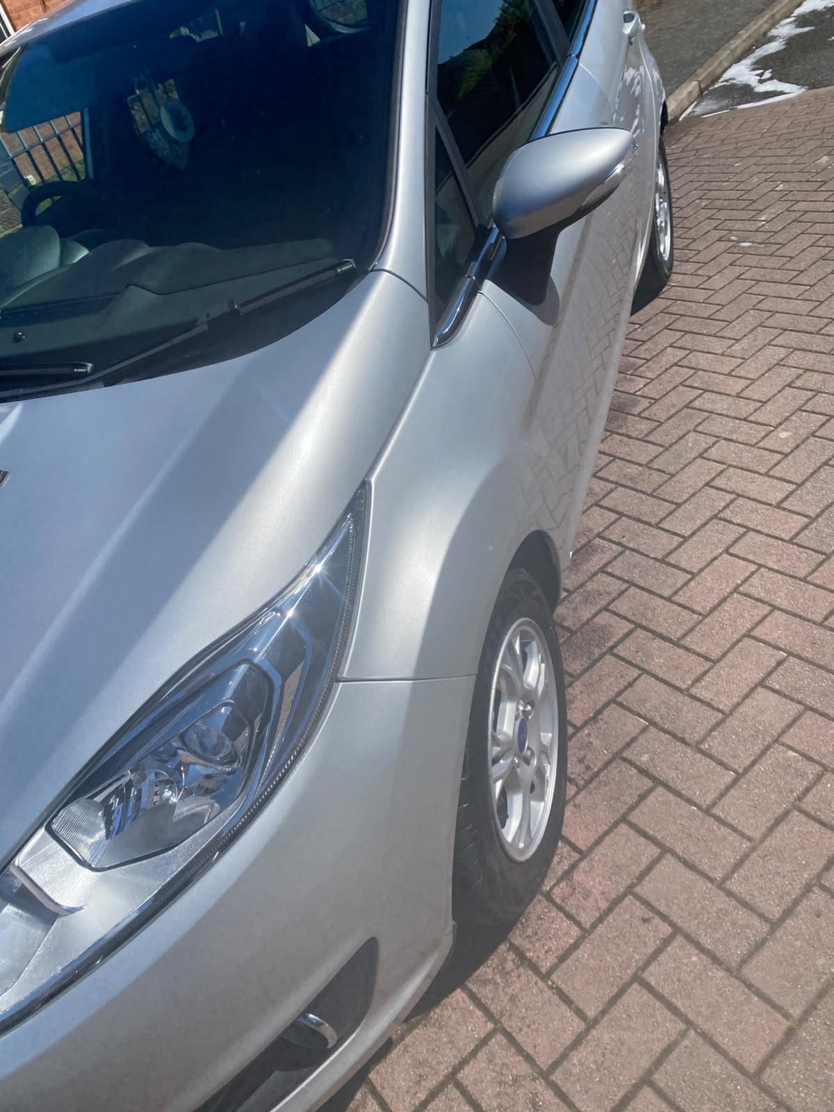 Silver Ford front wing and headlight after polishing