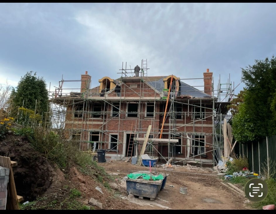 Large Bramcote new build under scaffold with brickwork and roof tiling in progress
